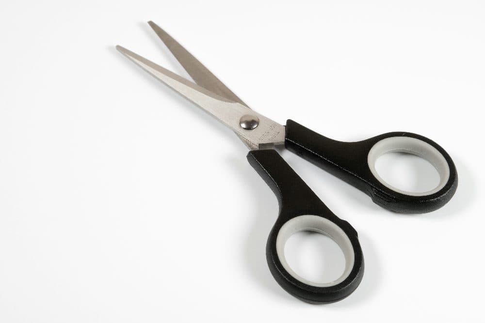 A pair of black-handled scissors on a plain white surface