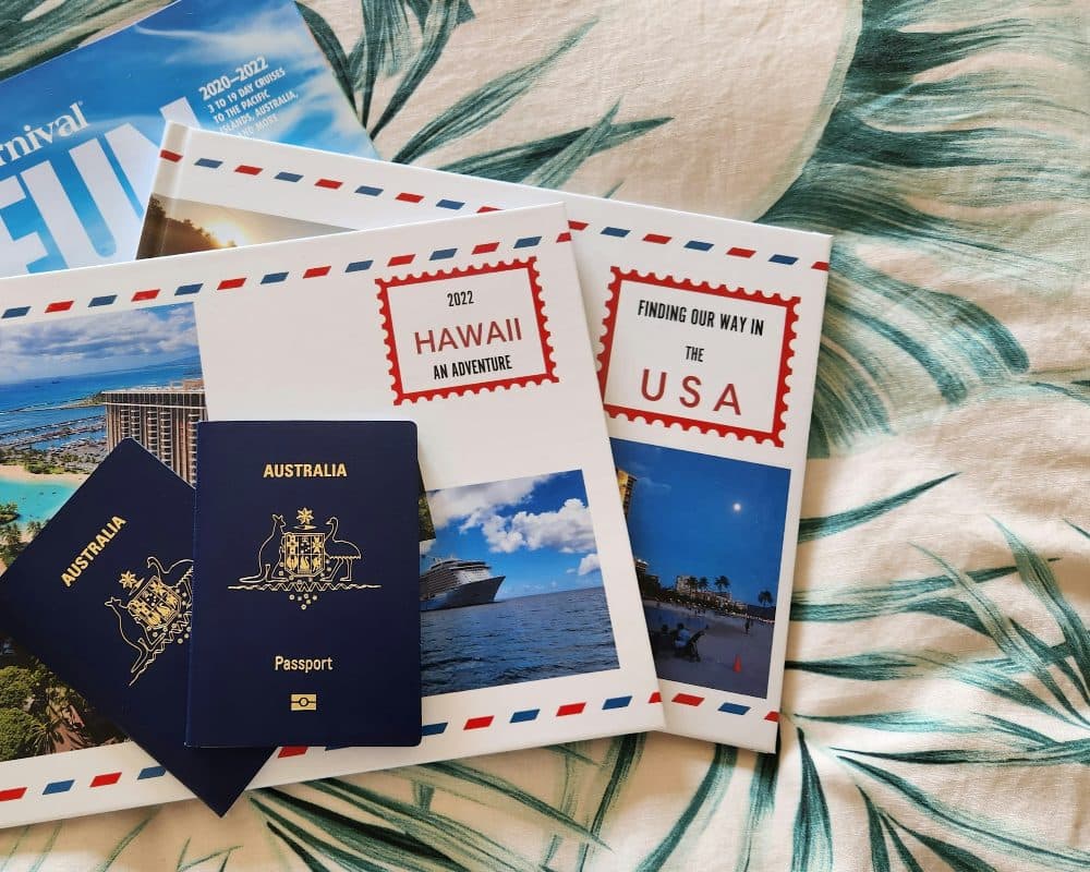 Two Australian passports and picture postcards from Hawaii lying on a leaf-patterned bedspread