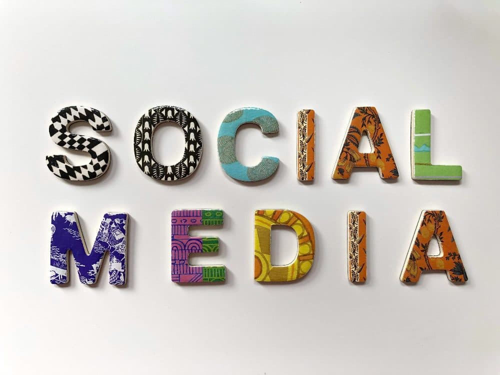 The words social media spelled out in patterned cut-out letters on a white background