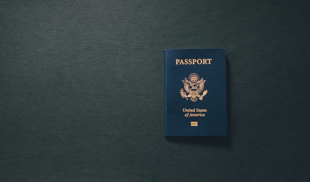 A dark blue passport lying on a plain black surface