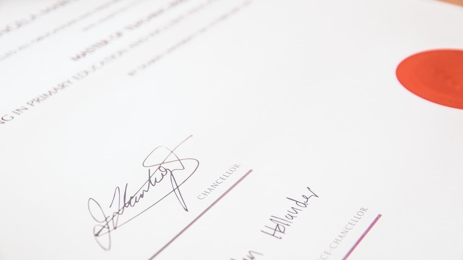 A university degree certificate with a red seal and two signatures