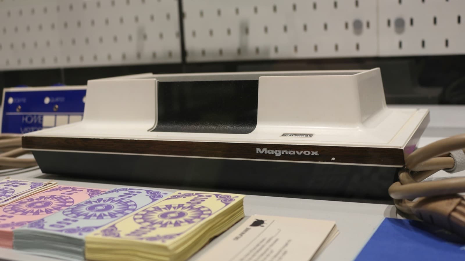 A desktop printer on a table next to a bundle of paper