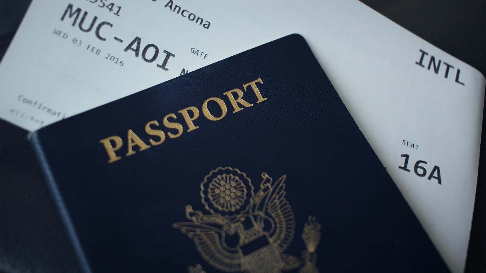 A closed passport booklet lying on a sheet of white paper