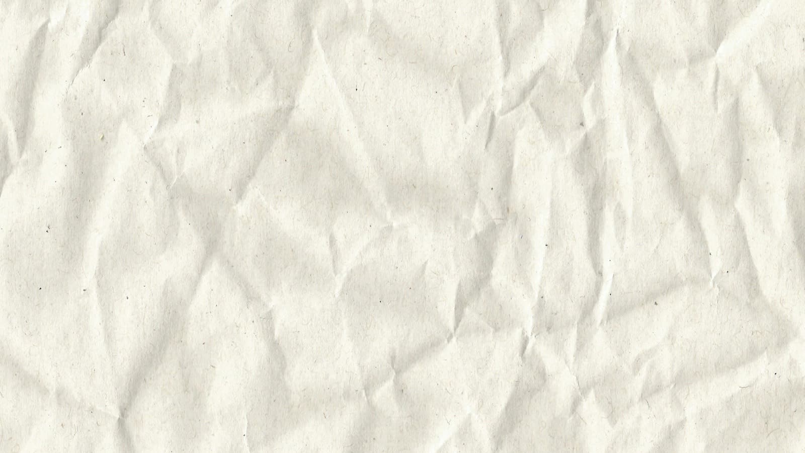 A sheet of white paper crumpled in half on a plain background