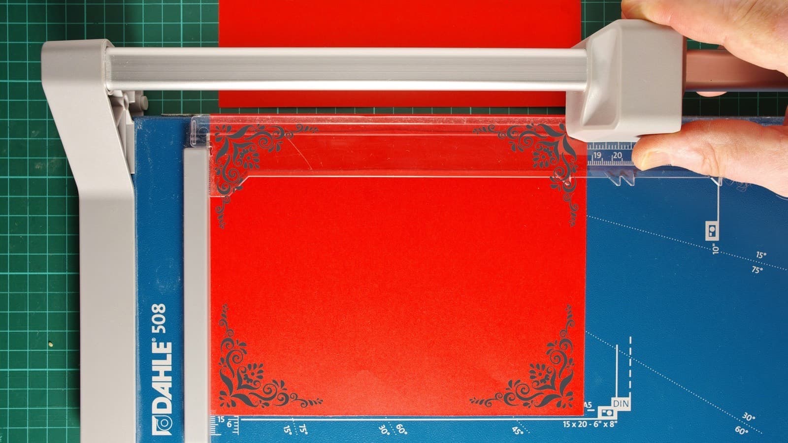 A person cutting a stack of paper with a guillotine paper cutter